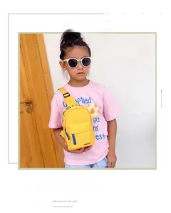 Detail of yellow nylon kids chest bag with blue zipper and floral charm accessory