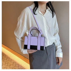 Lifestyle view of compact color-block crossbody bag in purple and black with shoulder strap
