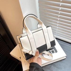 Detail of contrast color tote bag with smooth faux leather and gold hardware