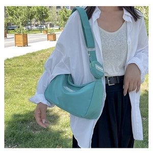 Detail der minzgrünen Crossbody-Tasche mit verstellbarem Gurt und kleiner runder Tasche