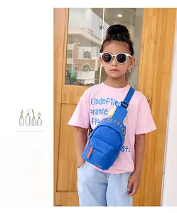 Blue nylon kids chest bag with orange zippers worn by a young girl outdoors