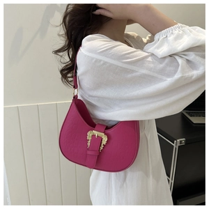 Detail of fuchsia half-moon shoulder bag with ornate gold-tone buckle on white shirt