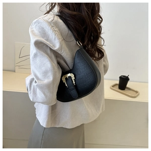 Model view of black crocodile-embossed crescent underarm bag with gold vintage buckle