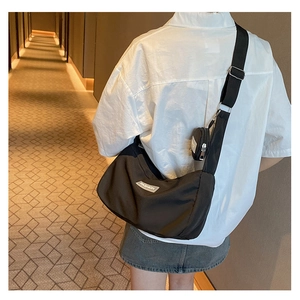 Detailansicht der schwarzen Nylon-Tasche mit abnehmbarem Münzfach und Mode-Label