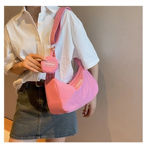 Detailaufnahme der rosa sichelförmigen Tasche mit passender runder Münzbörse und weißem Logo