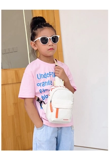 Close-up of white canvas kid's chest bag with orange zippers and FASHION logo