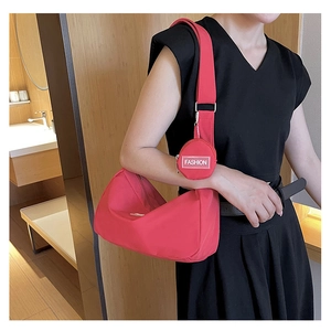 Detail der roten Halbmondtasche mit runder Geldbörse und Fashion-Gurt am Model