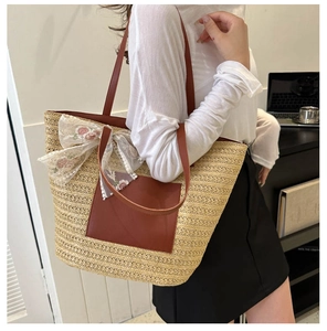 Detail of straw tote bag with lace bow, floral embroidery and brown leather shoulder straps