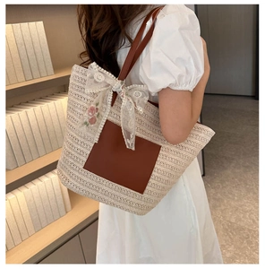 Close-up of woven tote bag with brown leather pocket and rose lace bow detail