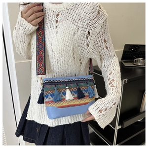 Close-up of bohemian crossbody bag with colorful weaving and tiered blue fringe detail