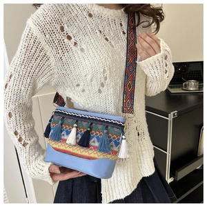 Detailed shot of ethnic crossbody bag featuring bohemian colorful woven texture and tassels