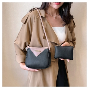 Detail view of pink and black contrast leather bucket bag with gold metal trim