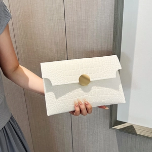 Elegant white envelope clutch bag with stone texture and a gold circular buckle