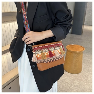 Close-up of bohemian shoulder bag featuring colorful embroidery and stylish long tassels
