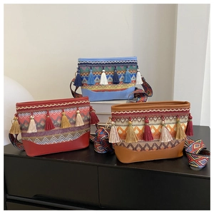 Close-up of bohemian crossbody bags with colorful tassels and ethnic woven straps