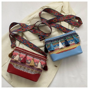 Detail of ethnic crossbody bags with colorful fringe and geometric pattern wide straps