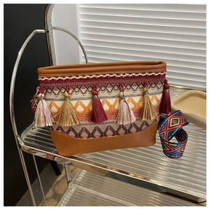 Detail of bohemian ethnic shoulder bag with colorful tassels and jacquard pattern strap