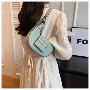 Detail of mint green shoulder bag with wavy gold buckle and adjustable strap