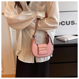 Detail of pink crescent hobo bag with a decorative gold geometric buckle on a handbag