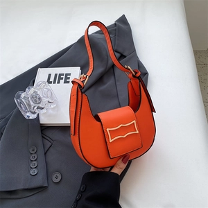 Detail of orange hobo bag featuring premium leather and unique gold metal buckle