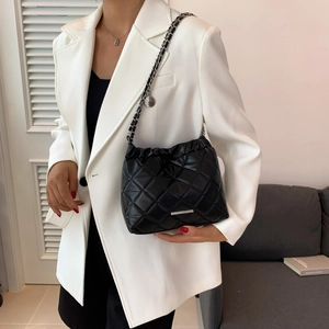 Modern black quilted crossbody bag with silver chain strap and minimalist metal logo