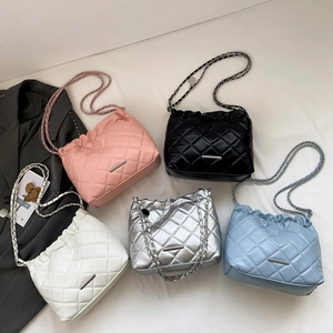 Quilted crossbody bag with chain strap shown in pink black white silver and blue colors