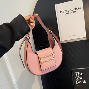 Chic pink semi-circular hobo bag with a stylish gold buckle and sleek shoulder strap