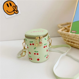 Détail du sac seau vert clair avec motif cerise et tirette de zip en forme de fleur