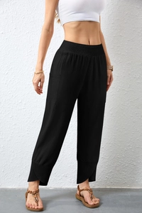 Detail of high-waist black cotton linen pants featuring tulip hem and side pockets