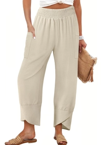 Detail of high waist elastic waistband and side patch pockets on beige linen pants