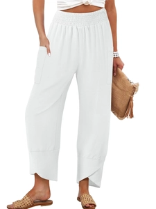 Detail of high waisted white wide leg pants featuring smocked waist and petal cut hem