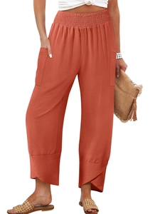 Detail of high waisted wide leg pants in brick red featuring elastic pleated waist