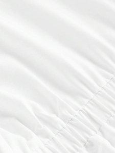 Primer plano de camisa blanca de manga larga con detalles fruncidos y textura de tela
