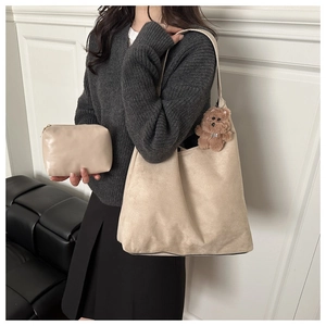 Detail of beige faux suede tote bag set with a cute plush bear pendant accessory