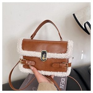 Gros plan du sac en cuir marron avec bordure en laine d'agneau blanche et fermoir doré