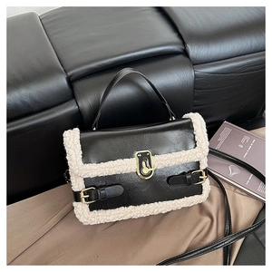 Détail du sac en similicuir noir avec bordure en peluche blanche et boucle en métal doré
