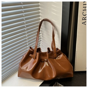 Détail du sac à bandoulière en cuir ciré marron brillant avec texture plissée et ombres