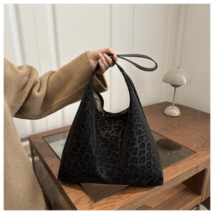 Gros plan d'un sac cabas léopard tendance avec anses noires dans un décor d'intérieur