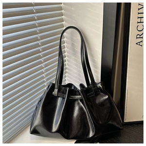 Gros plan du sac bandoulière en cuir ciré noir brillant avec plis texturés