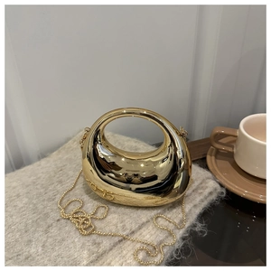 Close-up of golden metallic half-moon handbag with a chain strap on soft knit fabric
