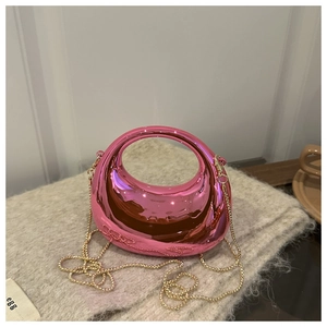 Detail of bright pink mini crescent bag with glossy mirror finish and gold chain strap