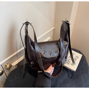 Détail du sac demi-lune vintage marron foncé avec clous métalliques et bandoulière réglable