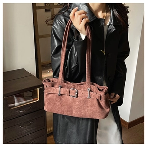 Detail of vintage brown suede shoulder bag with decorative straps and silver buckles