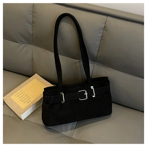 Detail of black suede shoulder bag featuring decorative silver buckle and matte texture