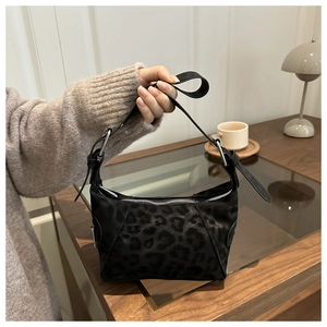 Detail of leopard print tote bag featuring silver hardware and adjustable shoulder strap