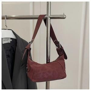 Detail of burgundy leopard print crescent bag with wide strap and metallic buckle