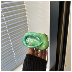 Detail of green marble acrylic handbag with polished texture and golden chain strap