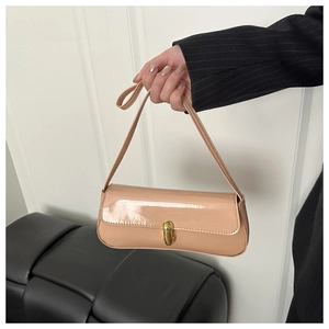 Dettaglio borsa in pelle verniciata beige chiaro con chiusura girevole in metallo dorato