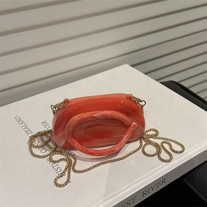 Orange marble acrylic clutch bag with round handle and gold metal chain strap