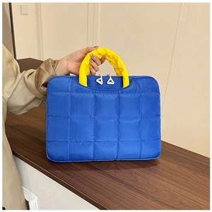 Detail of blue quilted document briefcase with yellow handles and double zippers